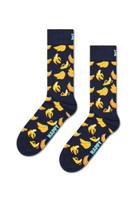 Chaussettes bleu marine présentant un motif de bananes répétées en jaune. Le mot "HAPPY" est tricoté en turquoise sur le haut. Mat ériau doux.