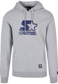 Grijze hoodie van zacht materiaal, met een groot marineblauw logo met een ster. Inclusief een kangaroo zak en ribbelboorden aan de mouwen en onderkant.