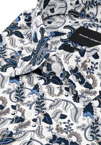 Biała koszula z detalnym niebieskim i brązowym wzorem kwiatowym, z klasycznym kołnierzykiem i białymi guzikami. Widoczna metka marki.