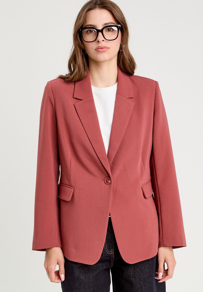 Rostfarbener Blazer mit taillierter Passform, Reverskragen, Einknopfverschluss und zwei vorderen Taschen. Glattes Material und strukturierte Silhouette.