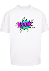 Camiseta de algodón blanca con un gráfico colorido de "¡BOOM!" en rosa y turquesa con acentos en negro y líneas de explosión en la parte delantera.