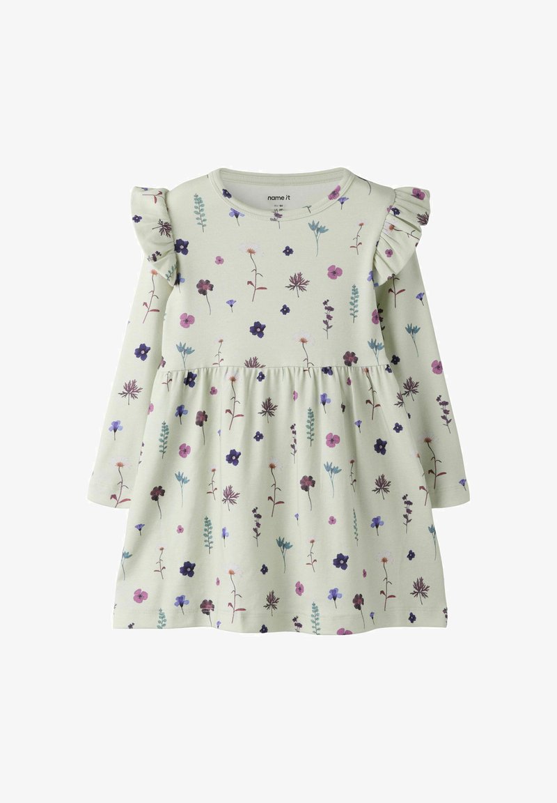 Robe à manches longues crème avec imprimé floral violet et rose, avec des détails froncés aux épaules et une taille froncée.