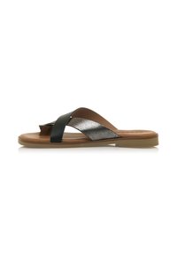 Sandali neri e metallici con finitura liscia, caratterizzati da cinturini sovrapposti, una suola piatta color tan e un design minimalista.
