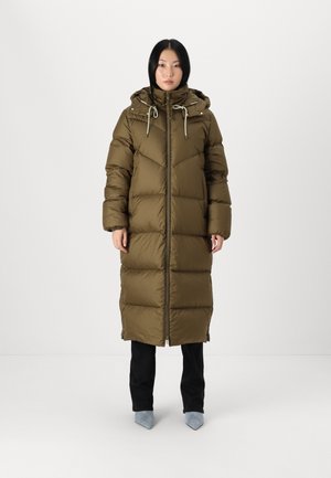 Olivovo zelený dlhý pufrový kabát s kapucňou, zipsom a šnúrkami. Kabát má prešívaný vzor a siaha po polovicu lýtok.