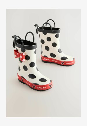 Hvide reg gummistøvler med store sorte prikker, røde detaljer og en rød sløjfe. Teksten "Minnie" fremhævet i den nederste kant. Tekstureret sort sål.