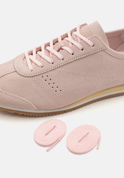 Lys rosa semsket sneaker med rund tå, snøring foran, perforerte detaljer, kontrasterende såle, ledsaget av matchende lisser.