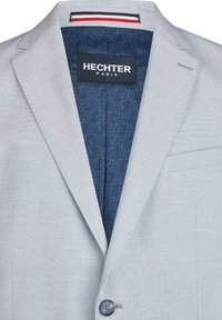 Heller grauer Blazer mit Reverskragen, einreihigem Knopfverschluss und blauem gemustertem Innenfutter. Verfügt über eine linke Brusttasche und detaillierte Nähte.