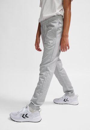 Gray sweatpants with an elastic waistband, side pockets, and a white logo on the hip. Combined with white athletic shoes featuring black accents.