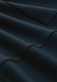 Tessuto blu scuro con una superficie liscia, che presenta pieghe morbide e cuciture sottili. Nessun motivo o accento visibile.