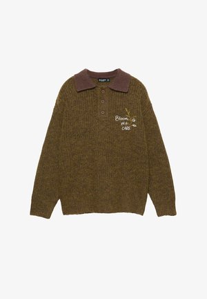 Strickpullover in olivgrün mit einem braunen Kragen, drei Knöpfen und gesticktem Text "Blühend mit Fürsorge." Weicher, strukturierten Stoff.