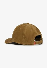 Braune Cord-Baseballmütze von hinten betrachtet, mit verstellbarem Riemen und kleinem roten Etikett auf weißem Hintergrund.
