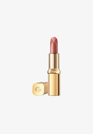 Rouge à lèvres dans un tube cylindrique doré, avec un mécanisme de rotation. La couleur est un rose doux. Le capuchon est embossé avec un logo.