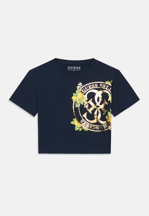 Μπλε σκούρο κοντομάνικο T-shirt με χρυσό λογότυπο GUESS, κίτρινες λεμονιές και πράσινα φύλλα τυπωμένα στη δεξιά πλευρά μπροστά.