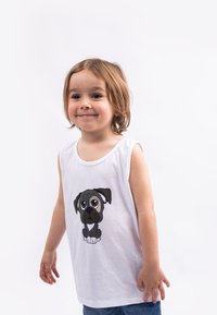 White sleeveless tank top featuring a printed illustration of a cartoon pug with big eyes. The child is wearing denim shorts.