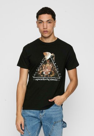 Sort bomulds t-shirt med et trykt trekantsgrafik med flerfarvede elementer og tekst, parret med blå denimjeans.