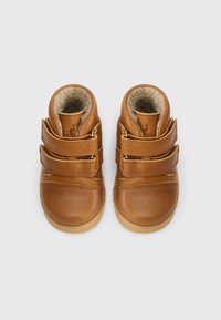 Botas de couro castanho para crianças pequenas com duas tiras de velcro, bico arredondado e um forro suave. Sola de borracha para maior tração.