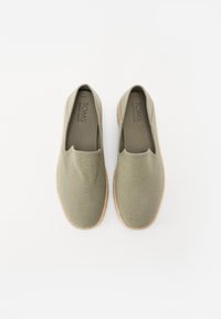 Bottes à enfiler en toile vert olive avec une tige texturée et une semelle en caoutchouc beige clair. Design minimaliste sans accents de matériel visibles.