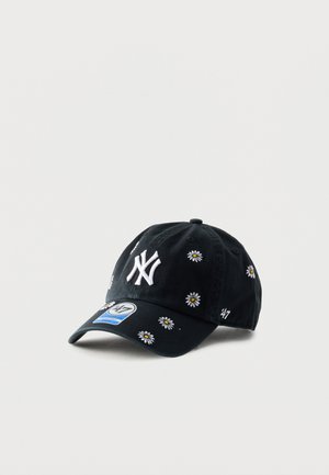 Juoda beisbolo kepuraitė su baltu New York Yankees logotipu, siuvinėtomis baltomis ramunėmis ir mėlynu „47“ prekės ženklo lipduku ant snapelio.
