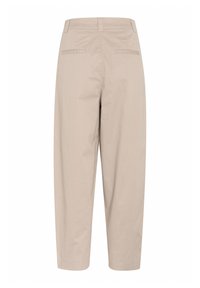 Béžové bavlněné kalhoty s uvolněným střihem, s kapsami na zadní straně, hladkým povrchem a středně vysokým pasem.