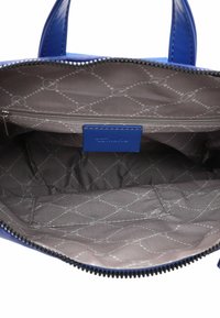 Open blauwe handtas met een grijs gedessineerde binnenvoering, een binnenvak met rits en een klein open vak.