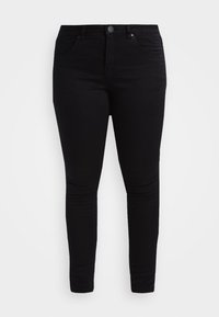 Vaqueros negros ajustados, hechos de una mezcla de algodón, con un diseño clásico de cinco bolsillos y lazos para cinturón. Textura suave con un ajuste ceñido.