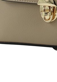 Beige leren handtas met een gestructureerd oppervlak, zwarte rand en gouden sluitingsdetail. Heeft een strak en gestructureerd ontwerp.