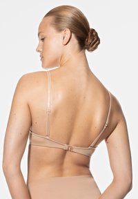 Huidskleurige beha met verstelbare bandjes, haak-en-oogsluiting, naadloos ontwerp en zachte stof, van de achterkant getoond.