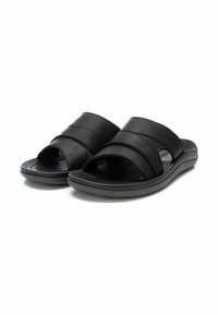 Chanclas negras de deslizamiento con dos correas horizontales anchas, hechas de cuero suave. Presentan una plantilla contorneada y suela texturizada para mayor agarre.