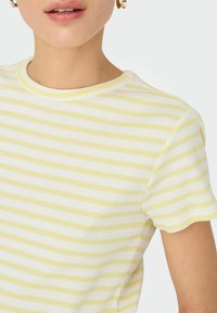Stribet T-shirt med korte ærmer i bl�ødt, tekstureret stof. Gule og hvide skiftende striber. Rund halsudskæring, tætsiddende design, subtil ribbning.
