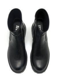 Botines de cuero negro que cuentan con un acabado suave, puntera redondeada, paneles laterales elásticos y una suela de goma texturizada.