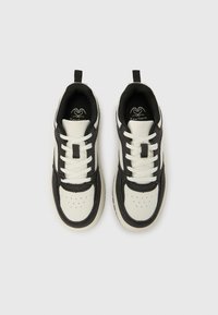 Adidași negri și albi cu talpă joasă, cu partea superioară din piele netedă, accente din țesătură texturată, șireturi albe plate și un design perforat în zona degetelor.