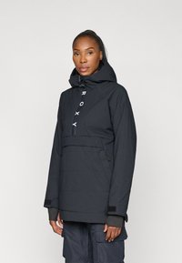 Must must jacket, mised pea ja kapuutsiga, ees on lukuga ja logot detailiga. Tekstuuritud kangas, reguleeritavad mansetid ja küljetaskud.