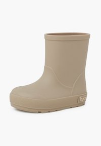Botte de pluie en caoutchouc beige avec une finition lisse, bout arrondi, hauteur de cheville basse et semelle texturée. Présente le logo de la marque sur le côté.