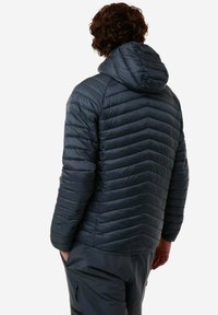 Giacca a vento imbottita grigio scuro con cappuccio, caratterizzata da un motivo a chevron trapuntato e una texture liscia. Progettata per calore e isolamento.