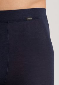 Shorts boxers pour hommes en bleu marine, fabriqués en tissu doux et extensible. Ils présentent une ceinture de marque et un design lisse et sans coutures pour un confort optimal.