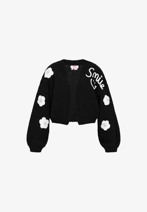 Schwarze gestrickte Strickjacke mit verkürztem Design, Ballonärmeln, weißen Blumenapplikationen an den Ärmeln und dem aufgestickten Text "Smile" auf der Vorderseite.