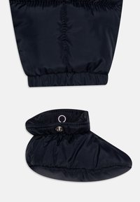 Navy puffer collar with quilted texture, featuring a snap button closure and a metallic accent, designed to fit comfortably around the neck.