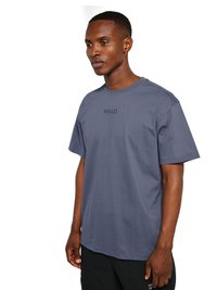 Homme portant un t-shirt bleu avec le logo "HALO" et un pantalon noir, debout de profil avec une expression neutre sur un fond blanc.