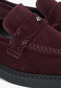 Bordeaux suède loafers met een gestikte accent, vlakke zwarte zool en decoratieve metalen knoop op de band. Textuur met gevlochten details.