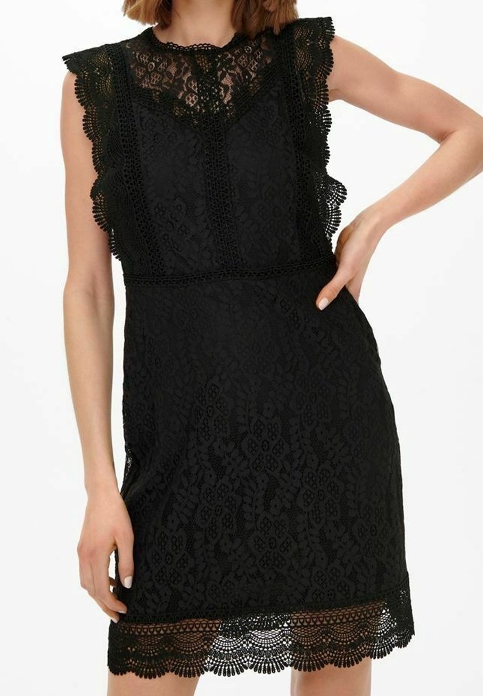 Svart spetsklänning med en scalloped halsringning och volangärmar. Invecklat blommönster och en dekorativ spetskant vid fållen.