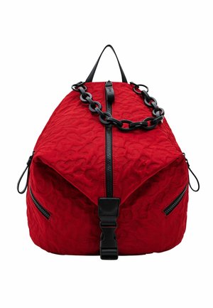 Mochila roja con textura, cremallera negra, cadena de plástico negra y hebilla negra en la parte frontal, mostrada sobre un fondo blanco.