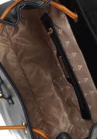 Musta käsilaukku, jossa on sileä pinta ja vaaleanruskea vuori, jossa on kuvio, sekä vetoketjulla suljettava tasku. Valmistettu oransseista kahvoista ja kultaisesta metallista.