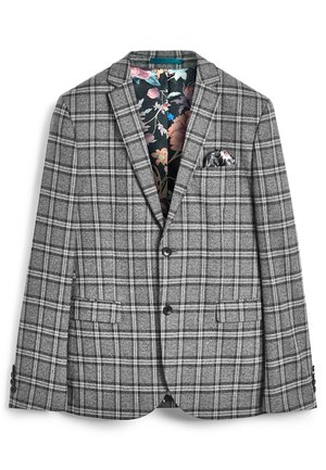 Grå ternet blazer med to knapper, klaplommer og blomstret inderfoer, med et blomster lommetørklæde i venstre brystlomme.