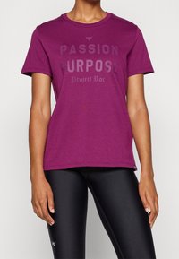 Fialové bavlněné tričko s krátkým rukávem, na přední straně s výrazným černým grafickým potiskem se slovním spojením "PASSION PURPOSE Project Roc".