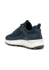 Zapatilla deportiva de color azul marino con una combinación de cuero y malla en la parte superior, cuello acolchado y una suela gruesa blanca con patrones en forma de olas.