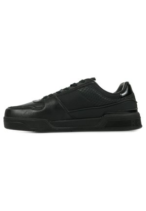 Zapatilla negra con parte superior de cuero liso, acentos de malla texturizada, puntera redonda, suela de goma plana y cierre de cordones.