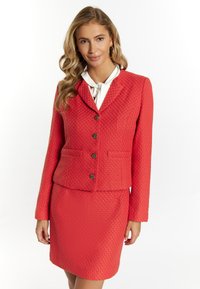 Roter strukturierten Anzug mit taillierter Jacke, die einen gekerbten Kragen und einen Knopfverschluss hat, kombiniert mit einem passenden knielangen Rock.