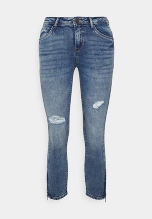 Jeans de ganga em azul médio com detalhes desgastados nos joelhos, ajuste slim, bainhas com fecho de correr, design de cinco bolsos e passantes para cinto.