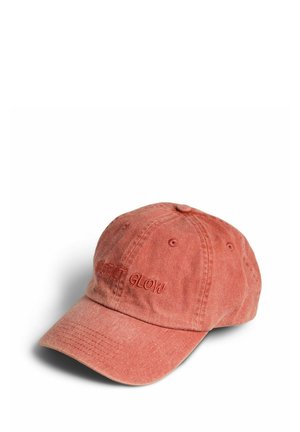 Vasket rød baseballkasket med broderet "DESERT GLOW" på fronten, vist mod en hvid baggrund.