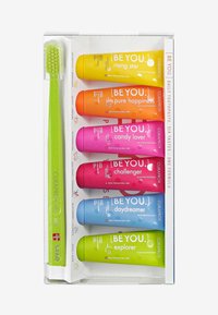 Ensemble de dentifrice composé de six tubes colorés : orange, rose, bleu, vert, jaune et violet, accompagné d'une brosse à dents verte à poils souples.